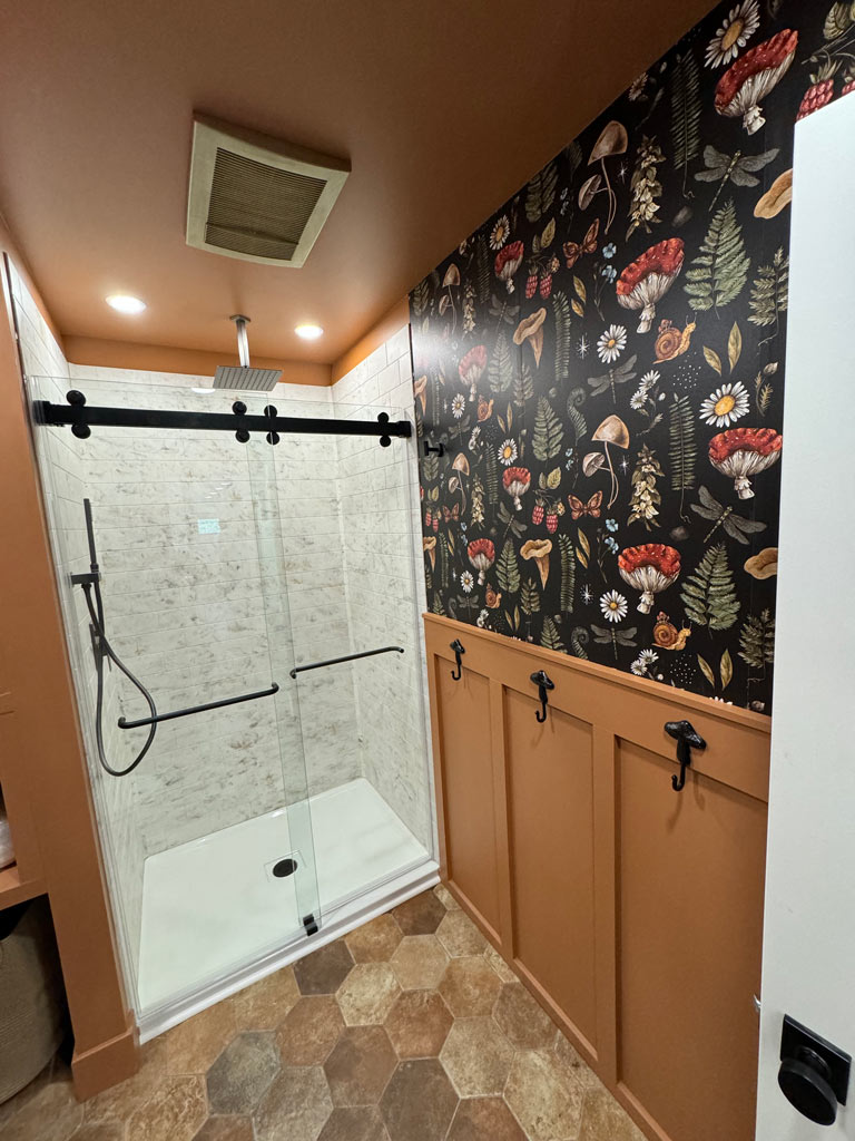 Modern bathroom with glass shower and floral wallpaper